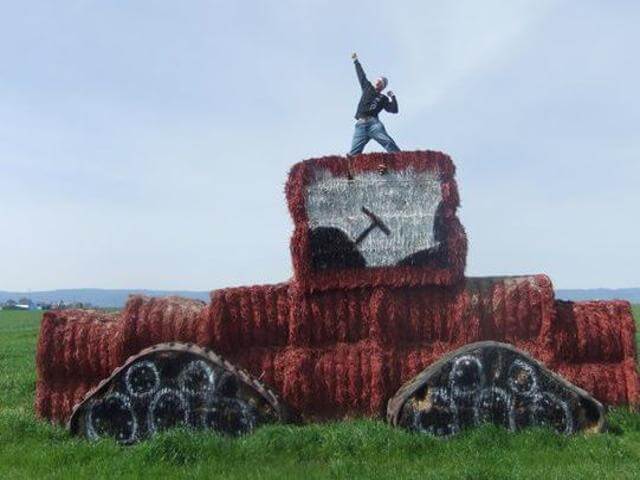 Aowanders posing for pictures on an artistic bail of hay that looks like a tractor found on the Pacific Coast Highway during an epic RV Road Trip in California